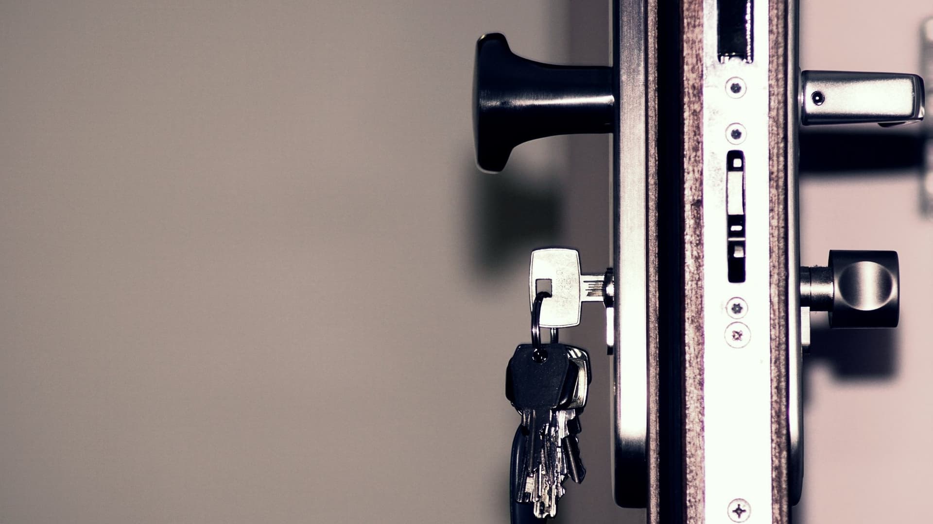 Serrurier remplaçant le cylindre d'une porte d'entrée, outils posés à côté